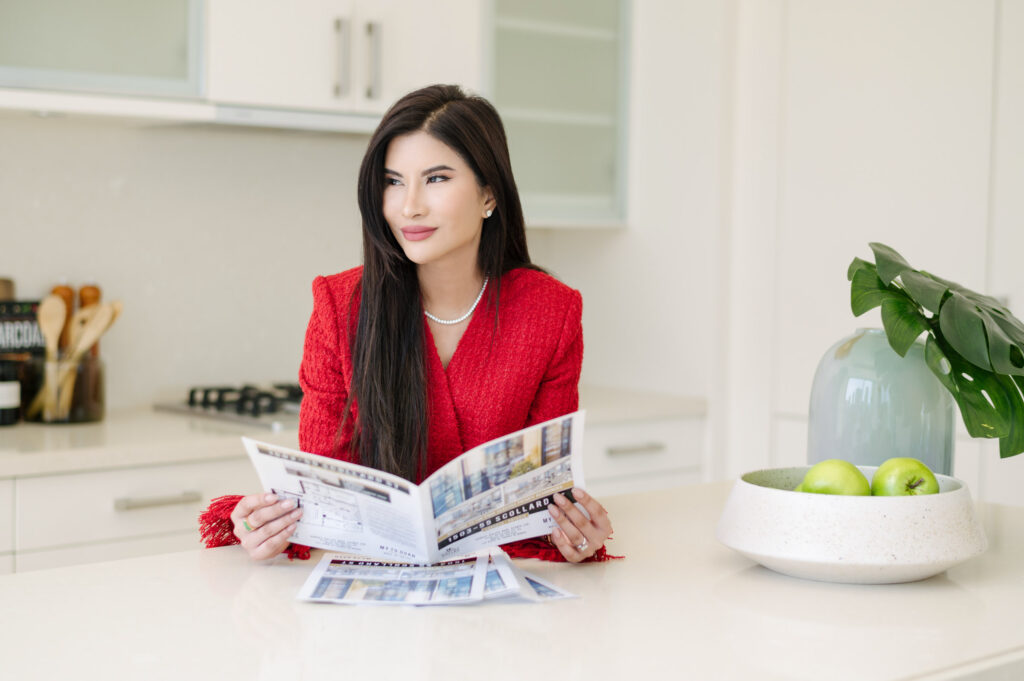 Woman in red tweed posing with listing magazine