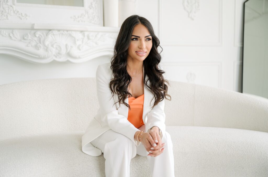 Professional woman in white suit sitting on couch, demonstrating branding photography