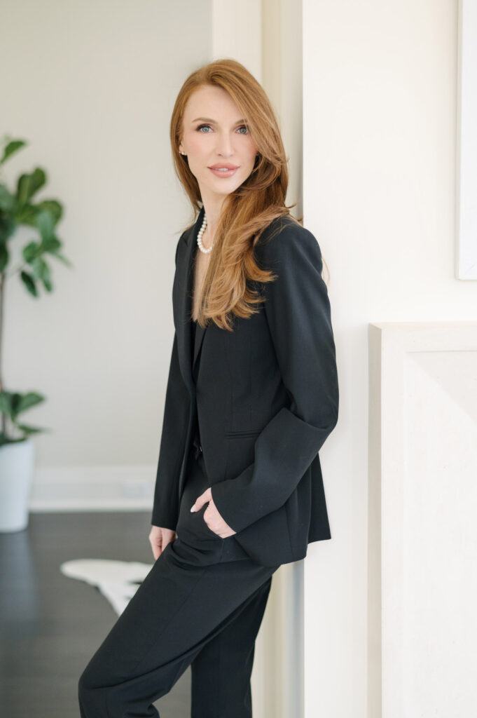 woman posed in a door way in a blue suit